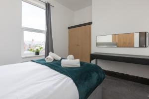 a bedroom with a bed with towels on it at Prism Everyday - One Bed Apartment in Blackpool