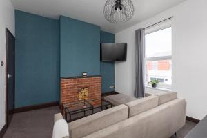 a living room with a couch and a fireplace at Prism Everyday - One Bed Apartment in Blackpool