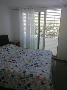 科米扎的住宿－M&D appartments，一间卧室,床上放着鲜花