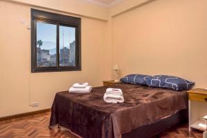 a bedroom with a bed with two towels on it at Departamento céntrico en la Ciudad de Salta, a 5 cuadras de la plaza principal in Salta
