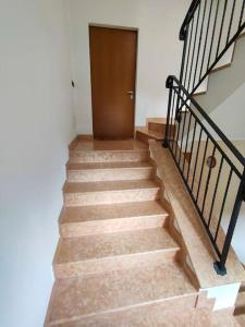 eine Treppe mit Holztür in einem Haus in der Unterkunft Appartamento al Parco, Brentonico in Brentonico