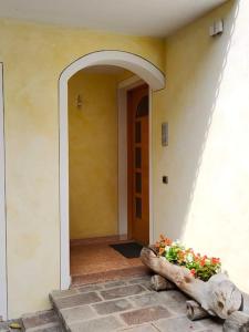 uma entrada para um edifício com um vaso de flores na frente em Appartamento al Parco, Brentonico em Brentonico