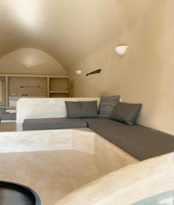a living room with a bed and a couch at Ambelia Traditional Villas in Oia