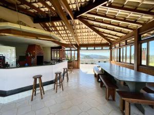 um restaurante com um bar com mesas e cadeiras em Chácara Mira Flores em Atibaia