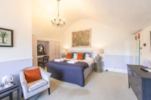 1 dormitorio con cama, escritorio y silla en The Woodlands Hotel, en Sidmouth