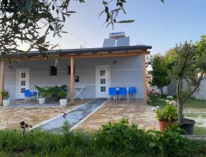ein Haus mit einer Terrasse und blauen Stühlen in der Unterkunft Gray&Oli Studios in Vlorë