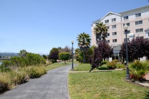 a walkway through a park next to a building at The Bayshore Hotel San Francisco Airport - Burlingame in Burlingame