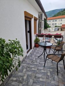 un patio avec des chaises et une table dans un bâtiment dans l'établissement Guesthouse Check In, à Stolac