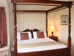 1 dormitorio con cama con dosel y lámpara en Yellow Mountain Hotel, en Skegness