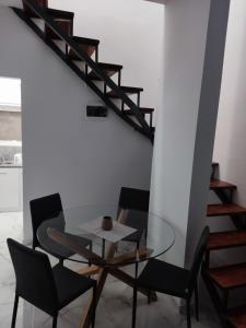 a dining room with a glass table and black chairs at Eleven And A Half apartment Superior in Nea Fokea