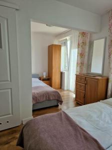 a bedroom with two beds and a dresser and a mirror at Stella Maris in Karwia