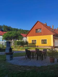 a table and chairs in front of a house at Apartmán Dobrá mysl in Hostinné