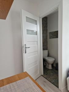 a bathroom with a door leading to a toilet at Stella Maris in Karwia
