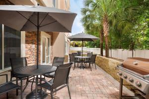 un patio con mesas, sillas y una parrilla en Fairfield Inn & Suites Jacksonville West/Chaffee Point, en Jacksonville