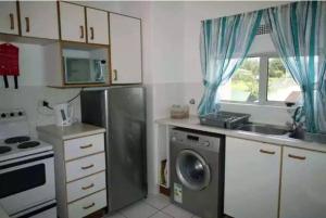 a kitchen with a stainless steel refrigerator and a dishwasher at Laguna La Crete-Uvongo in Margate