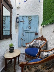 a patio with two chairs and a table and a blue door at ÇAKIR's HOME OTEL in Çeşme