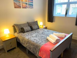a bedroom with a bed with two lamps and a window at Marine Apartment Whitley Bay Seaside Location Free Onsite Parking in Whitley Bay