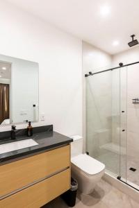 La salle de bains est pourvue de toilettes et d'une douche en verre. dans l'établissement Brand NEW Luxury 2bd Townhouse Pet-Friendly FREE Parking, à Los Angeles