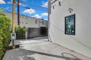 a white building with a gate and a driveway at Brand NEW Luxury 2bd Townhouse Pet-Friendly FREE Parking in Los Angeles