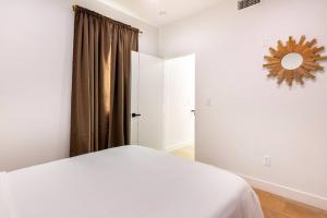 - une chambre blanche avec un lit et un miroir dans l'établissement Brand NEW Luxury 2bd Townhouse Pet-Friendly FREE Parking, à Los Angeles
