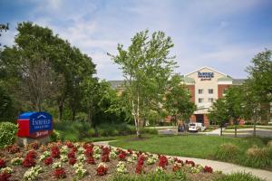 un hotel con un giardino fiorito di fronte a un edificio di Fairfield Inn & Suites White Marsh a Baltimora