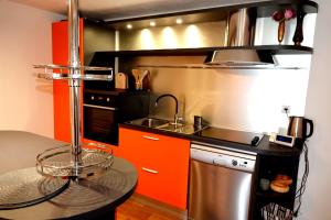 a kitchen with orange and black cabinets and a sink at Isabella in Silba