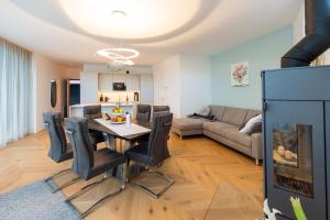 uma cozinha e sala de estar com mesa e cadeiras em Seehaus SeeZeit - Am Hafen em Neusiedl am See
