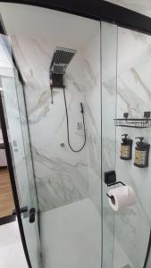 uma casa de banho com um chuveiro com um rolo de papel higiénico em Studio Praia do Jardim 1 305B em Angra dos Reis