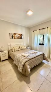Un dormitorio con una cama grande y una ventana en La Pedrera en Villa María