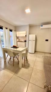 uma cozinha com uma mesa e um frigorífico branco em La Pedrera em Villa María