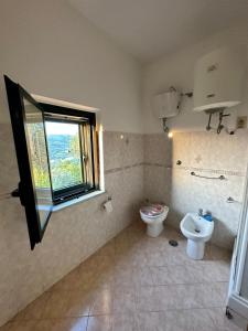 baño con aseo y lavabo y ventana en Casa Nonna Sofia, en Roccadaspide