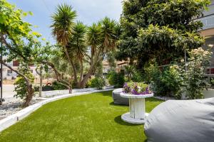 a garden with a table and some plants and trees at Ianos Apartments in Potos +45 photos