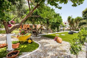 a garden with a tree and a wheelbarrow at Ianos Apartments in Potos