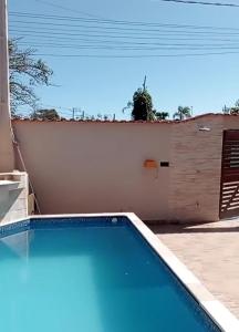 a swimming pool in a backyard with a fence at Casa de praia Melo in Itanhaém