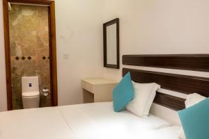 ein Schlafzimmer mit einem Bett mit einem blauen Kissen darauf in der Unterkunft LVIS Village in Dharavandhoo