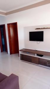 a living room with a flat screen tv on a wall at Casa de praia Melo in Itanhaém