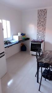 a kitchen with a table and a refrigerator and a stove at Casa de praia Melo in Itanhaém