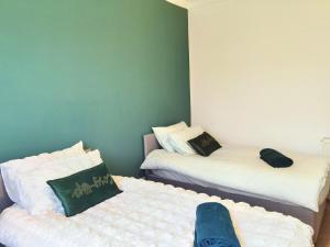 two twin beds in a room with white sheets at Parkside 2 bedrooms appartment with encolsed garden in Largs