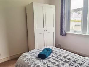 a bedroom with a bed with a blue pillow on it at Parkside 2 bedrooms appartment with encolsed garden in Largs