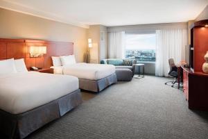 a hotel room with two beds and a television at Courtyard Indianapolis Downtown in Indianapolis