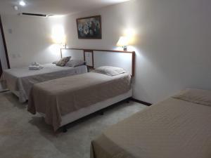 Habitación de hotel con 2 camas y 2 lámparas en Victoria Marina Flat 2203, en Salvador