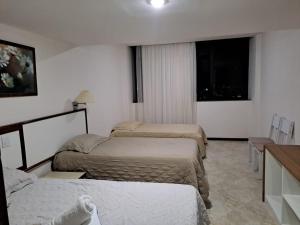 una habitación de hotel con 3 camas en una habitación en Victoria Marina Flat 2203, en Salvador