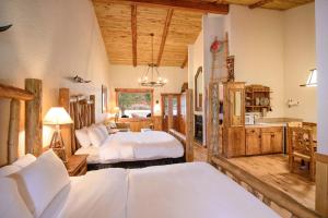 une chambre avec deux lits dans une pièce avec des plafonds en bois dans l'établissement Sorrel River Ranch Resort and Spa, à Castle Valley