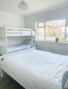 a bedroom with two bunk beds and a window at Lovely Bungalow Close to Beach in Prestatyn