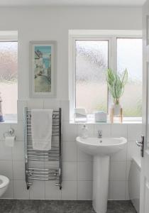 een witte badkamer met een wastafel en een toilet bij Lovely Bungalow Close to Beach in Prestatyn