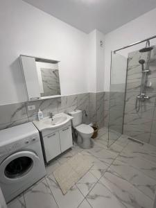 a bathroom with a washing machine and a toilet at Sunny Apartments Suceava 64 in Suceava