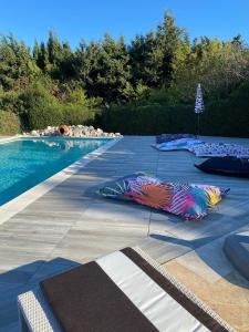una piscina con sombrillas en el suelo junto a ella en Mirabelle en Provence, en Eygalières