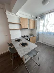 a kitchen with a table and chairs in a room at Sunny Apartments Suceava 64 in Suceava