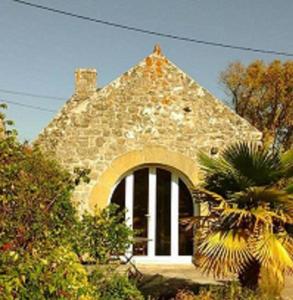 a brick house with a large window in front of it at Penty au Ménec in Carnac