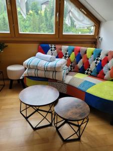 a couch with colorful pillows and tables in a room at green hill in Bad Kleinkirchheim